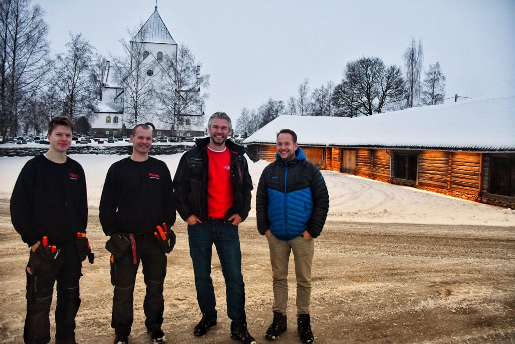 Stolte karer foran en opplyst kirkestall med Ås kirke i bakgrunnen. Fra venstre: Tor Erik Berget og Roberto Marciulaits, begge Minel Gjøvik Installasjon, Ole Tian Jarlvang, Byggservice Innlandet og Trond Gran Holte i eiendomsavdelingen i Vestre Toten kommune.