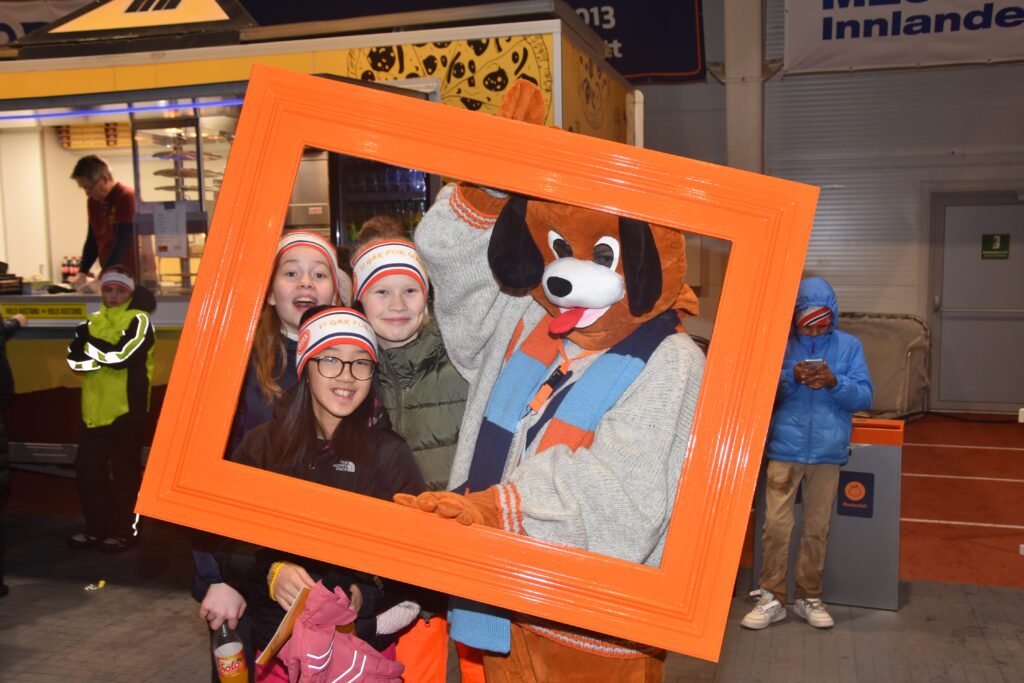 Tilde Ausrød Wirkestad, Wilma Linnerud Lilleengen og Jiajin Lia fra sjette trinn på Gjøvik International school ville gjerne ha en selfie sammen med NM-maskoten. (Foto: Torbjørn Aurvåg)